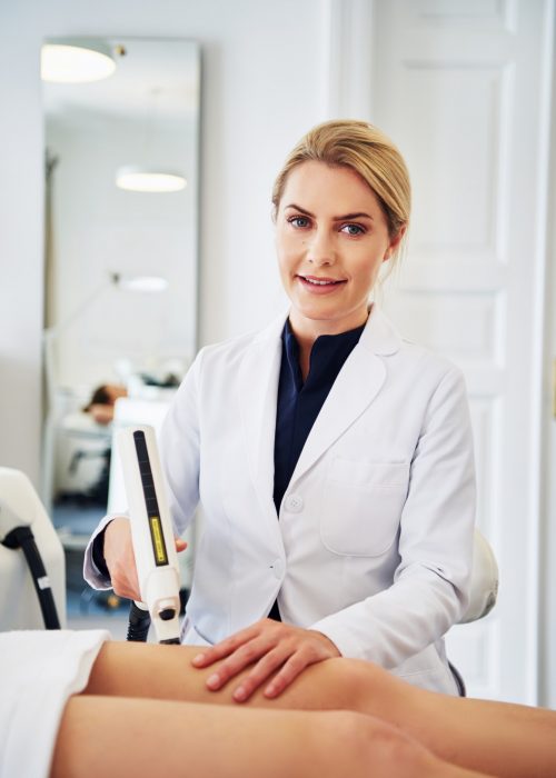 smiling-clinic-technician-performing-electrolysis-on-a-client-s-leg.jpg
